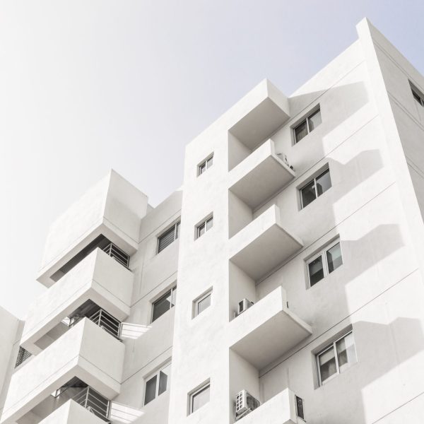 low-angle-shot-facade-white-modern-building-blue-clear-sky-scaled.jpg